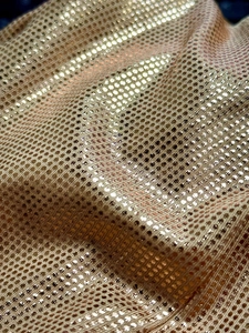 Vue macro détaillée du tissu en maille dorée avec pois réfléchissants et texture élastique