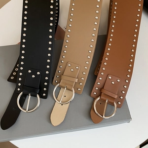 Detailed shot of vintage leather belts with silver rivets and large circular buckles