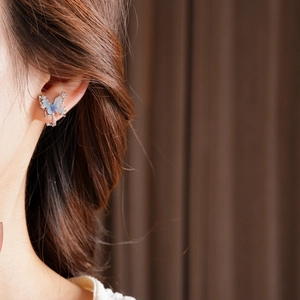 Close-up of 18k gold plated butterfly ear cuff with gradient blue zircons on ear