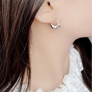 Close-up of S925 sterling silver star hoop earrings worn on a model's ear