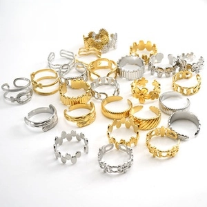 Detalle de anillos ajustables de acero inoxidable vintage en tonos oro y plata geométricos