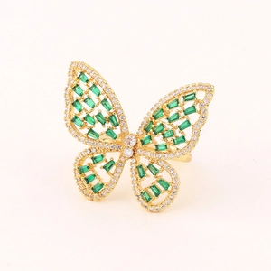 Macro view of gold butterfly ring with green crystals and white pavé zircons