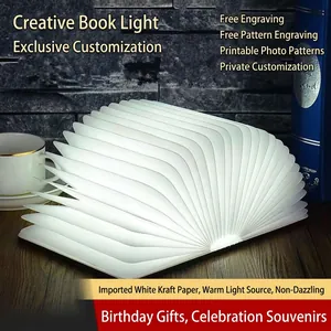 Modern wooden book-shaped lamp with warm LED light unfolding into a paper fan design