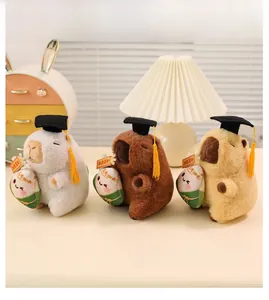 Close-up of three colorful capybara plush toys wearing graduation caps and holding rice dumplings