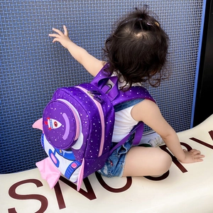 Toddler wearing purple rocket backpack with space pattern and pink side wing details