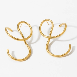 Abstract twisted golden earrings with irregular metal wire design on white background