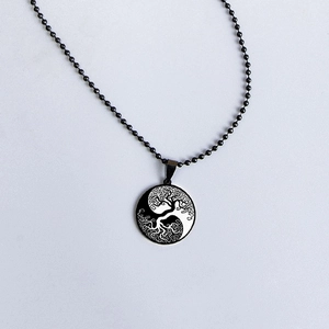 Macro detail of Tree of Life and Yin Yang pendant with a black ball chain necklace