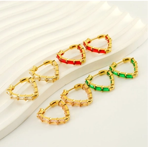 Macro view of heart-shaped hoop earrings with baguette-cut gemstones in multiple colors