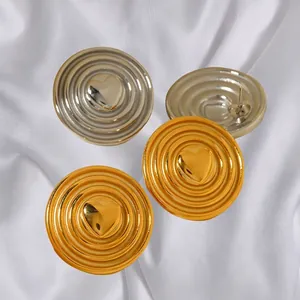 Orecchini a spirale in oro 18k e argento con motivo a cuore su seta bianca
