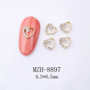 Macro view of heart-shaped gold alloy nail art charm with rhinestones and 6.5mm size specs