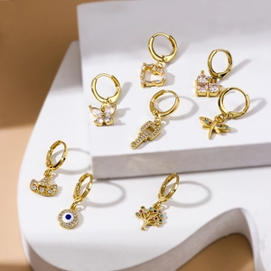 Golden butterfly and heart zircon charms arranged on geometric stands for multiple piercings