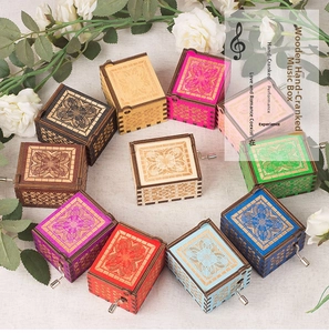 Top view of hand-cranked wooden music boxes with floral laser-cut patterns and vintage feel