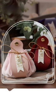Close-up of luxury velvet and PU leather wedding candy bags with pearl charms and gold ribbons