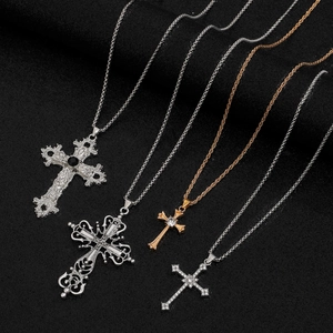 Vue macro de colliers croix gothiques avec détails en argent et or rose sur velours noir