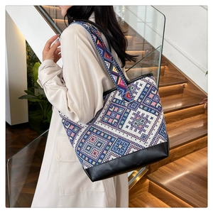 Close-up of geometric ethnic tote bag with wide strap and black leather bottom panel