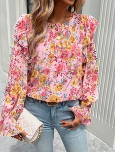 Close-up of pink floral chiffon blouse with ruffle details and long sleeves in a soft light