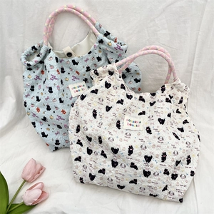 Detail of cartoon bubble texture tote bags with woven handles and cute cat patterns