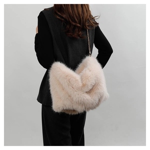 Close-up of beige faux fur tote bag with golden metal chain strap on model