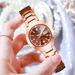 Gros plan sur montre or rose avec cadran marron affichant le jour, la date et des index brillants