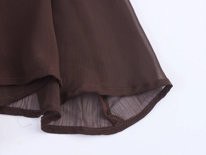Detailed view of the dark brown chiffon hem with professional stitching and sheer texture