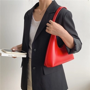 Minimalist red PU leather crescent shoulder bag styled with a professional black blazer