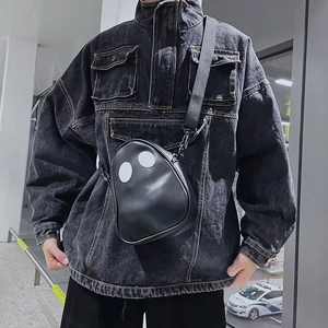 Close-up of black PU crossbody bag featuring cartoon ghost eyes and wide strap on model