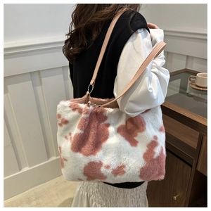 Detail of pink cow print plush tote bag with soft faux fur and leather shoulder strap