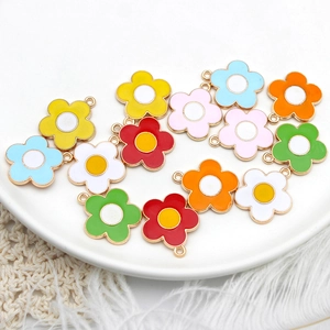 Colorful alloy flower charms in a ceramic dish for DIY necklaces and jewelry making