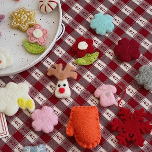 Flat lay of colorful wool felt Christmas crafts including elk, stars and snowflakes