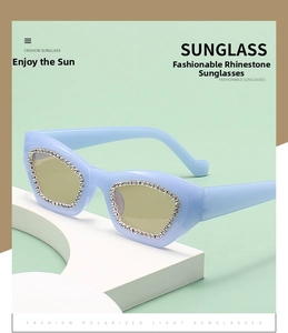 Detail of blue cat-eye sunglasses with white rhinestones and polarized brown lenses