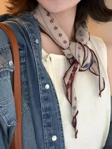 Detail of vintage floral pattern neckerchief styled with denim jacket for women