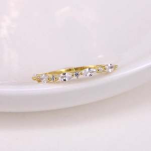 Macro shot of luxury gold ring with clear gemstones on a white ceramic plate