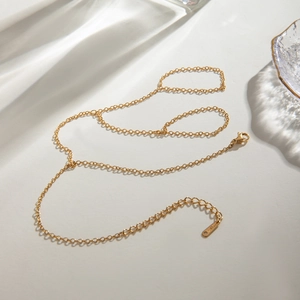 Detailed view of elegant gold stainless steel O-chain on aesthetic neutral background