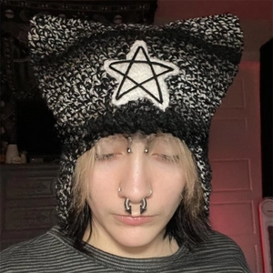 Close-up of handmade cat ear beanie featuring knit star patch and striped tassel details