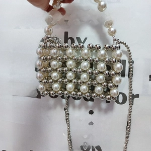 Detail of silver beaded mini bag with pearls showing hand strap and chain strap detail