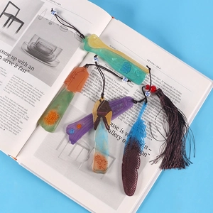 Selection of colorful feather and tassel bookmarks on a magazine for DIY resin art display