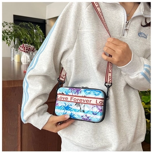 Mini sac bandoulière bleu à motif palmier avec sangle Love Forever porté par mannequin