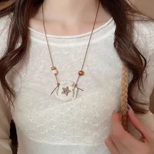 Handmade woven frog pouch necklace with star button pendant for a forest-inspired look