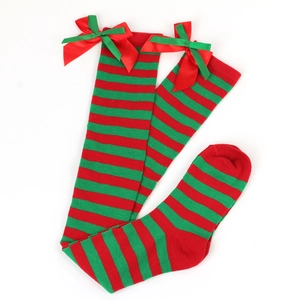 Detail of festive over-the-knee socks with red and green stripes and satin bows