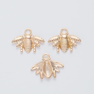 Detailed macro view of three golden bee-shaped alloy charms with intricate textures