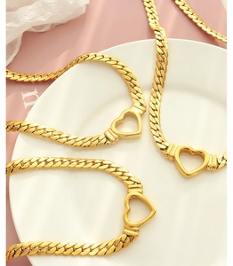 Vue détaillée de colliers en maille gourmette plaqués or 18 carats avec motif de cœur