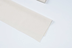 Detailed macro view of the cream white plain fabric and sleeve cuff on the dress