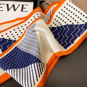 Elegant silk scarf with orange blue dots and stripes on dark textured background