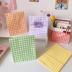 Colorful plaid paper bags in orange, purple, green, and yellow for gifts and storage