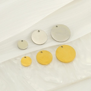 Close-up of DIY smile face charms in gold and silver finish on white background