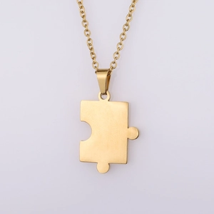 Macro detail of golden puzzle piece pendant necklace with a brushed metallic finish