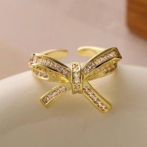 Minimalist 18K gold plated hollow bow ring with sparkling zircon in a 45-degree angle view