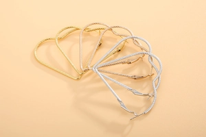 Detailed view of heart-shaped hoop earrings in gold, rose gold and silver textured finish