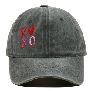 Primo piano di un cappellino da baseball in cotone lavato grigio con ricamo XOXO
