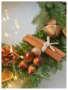 Close-up of Christmas wreath with pine cones, cinnamon sticks, and festive berries